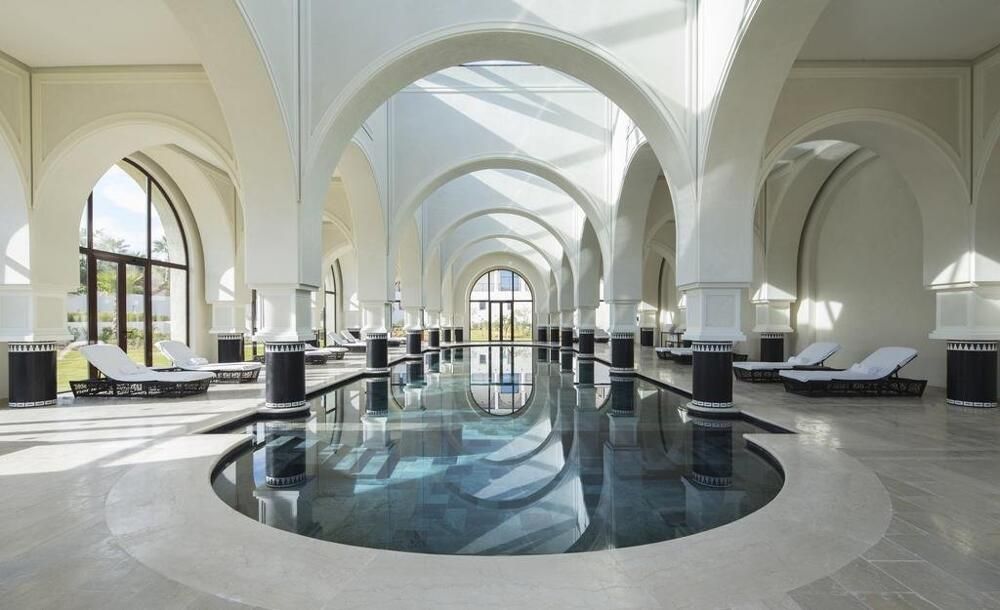 Indoor pool under white arches